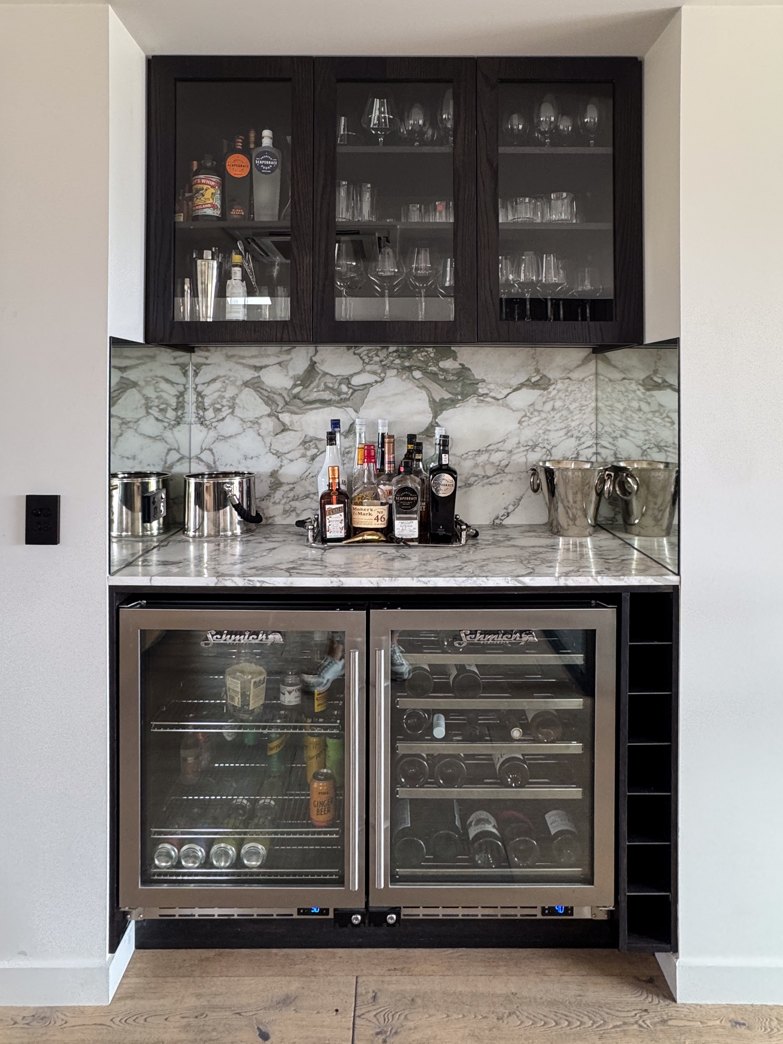 Built-in bar with marble splashback, glass-fronted cabinetry and Schmick wine fridges